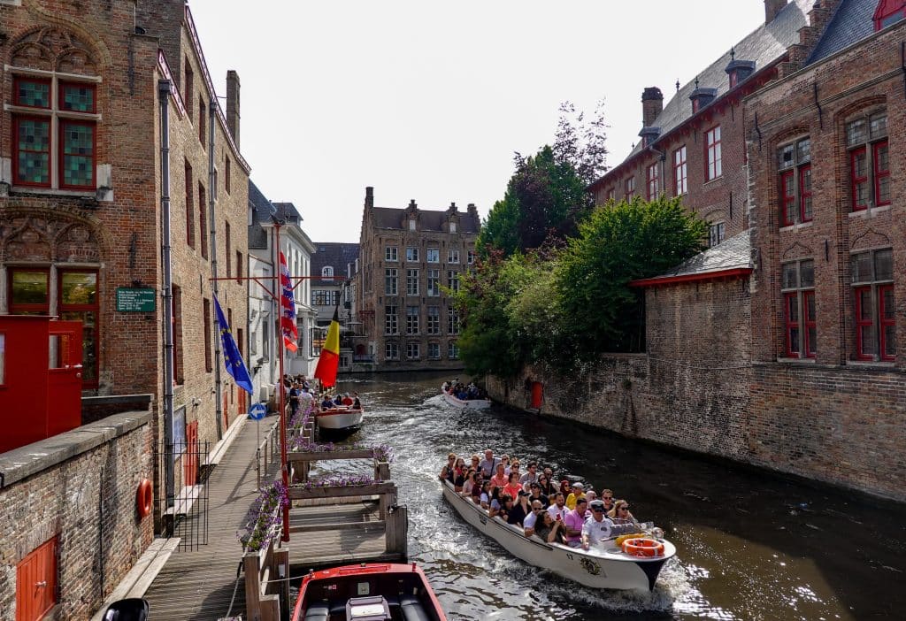 A group of tourists taking a boat tour on the canals of Bruges