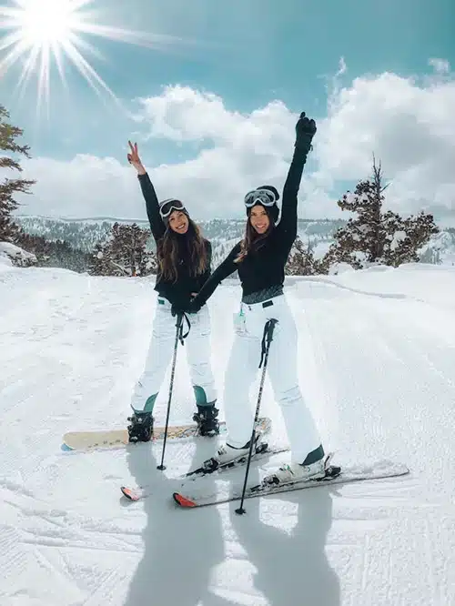 2 women on a ski hill dressed in ski clothes 